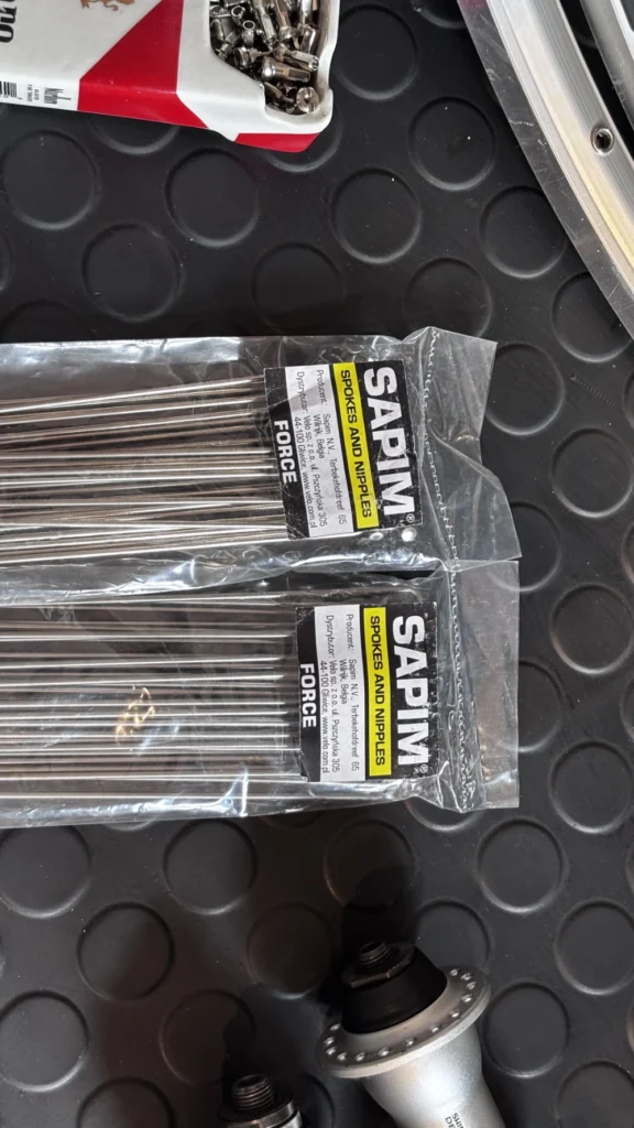 Szprychy Sapim podczas zaplatania koła rowerowego w serwisie – precyzyjne napięcie i centrowanie